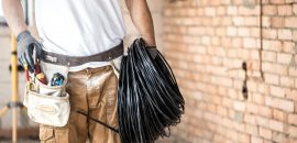 Electrician with tools, working on a construction site. Repair and handyman concept. House and house reconstruction.